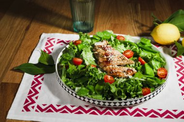 Kızarmış tavuk salatası, yeşil marul, ızgara et, yeşil bezelye, domates, limon, taze ve sağlıklı Akdeniz usulü yemek.