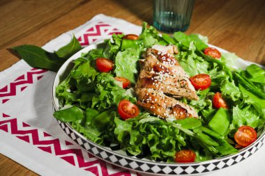 Kızarmış tavuk salatası, yeşil marul, ızgara et, yeşil bezelye, domates, limon, taze ve sağlıklı Akdeniz usulü yemek.