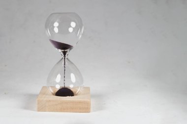 Cam kum saati ya da nötr beyaz gri arka planda manyetik kumlu kum saati.