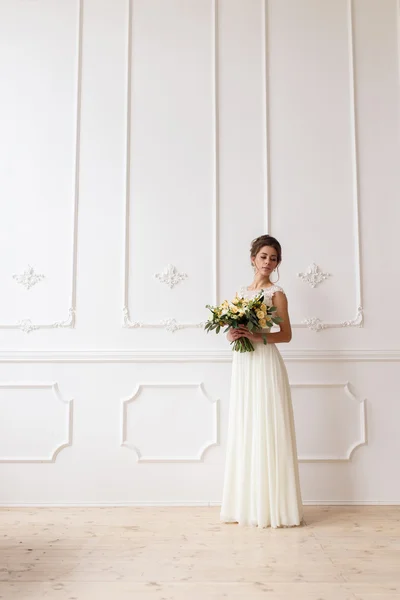 Bruid houden bruiloft boho boeket op een achtergrond van een witte muur opluchting — Stockfoto