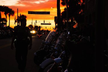 Daytona 'nın ana caddesinde gün batımı bisiklet haftası polisle karanlıkta.