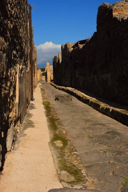 Arka planda Vesuv volkanı olan Pompeii 'deki boş ana cadde.