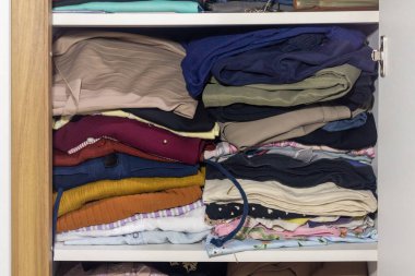 Dolapta katlanmış kıyafet yığını var.