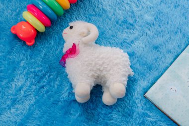 Mavi oyun hasırının üzerinde koyun bebeği