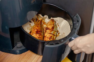 Baharatlı uskumru kızartan bir kadın.