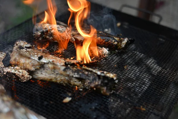 火の上にグリルで箔で魚を焼きます ピクニック料理 自然の中でグリルの木から火と熱 — ストック写真