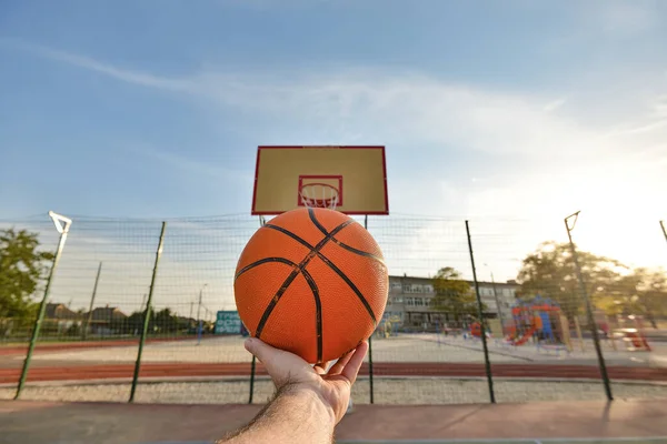 Handen Manlig Idrottsman Håller Basketboll Bakgrunden Sköld Med Ring Idrottsaktiviteter — Stockfoto