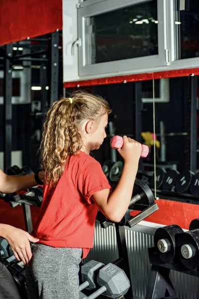 Dziewczyna Hantlami Jest Zaangażowany Siłowni Kobieta Trener Pomaga Ćwiczeniach — Zdjęcie stockowe