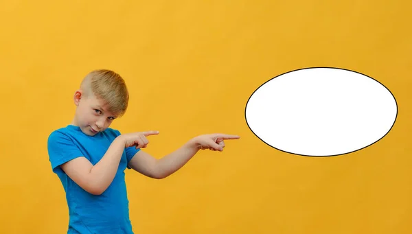 The boy points his finger to the place for an inscription in the form of a white oval on a yellow background. Space for text, advertising on a white background