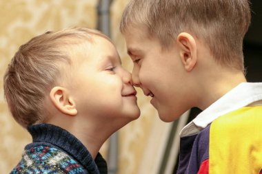 İki küçük kardeş burunlarını birbirlerine yasladılar. Aile dostluğu ve aşk kavramı.