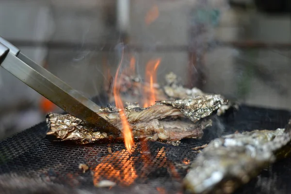 火の上にグリルで箔で魚を焼きます ピクニック料理 自然の中でグリルの木から火と熱 — ストック写真