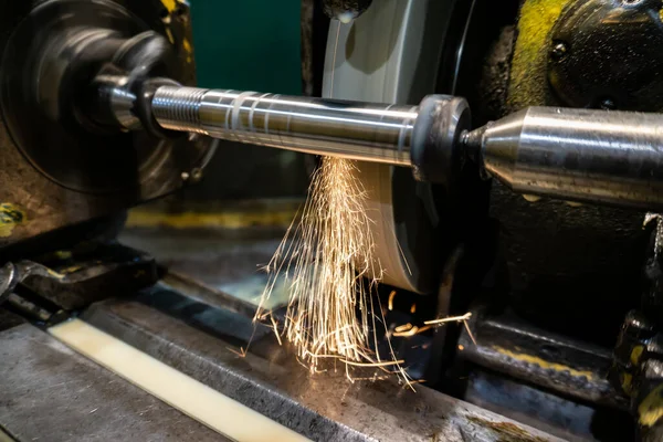 Grinding and processing a part on a grinding machine at a manufacturing enterprise, sparks from the abrasive fly in different directions.