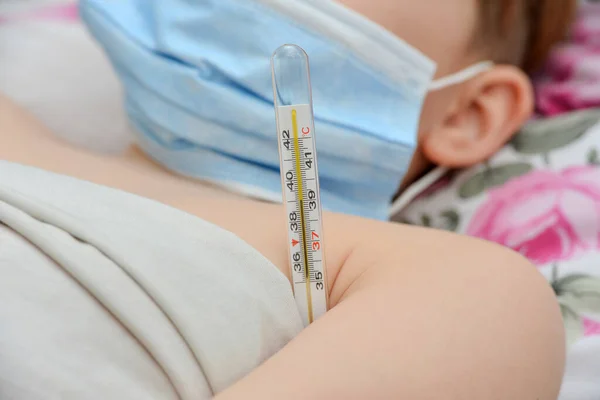 Gyermek Ágyban Fekszik Orvosi Maszkban Fokos Hőmérővel — Stock Fotó
