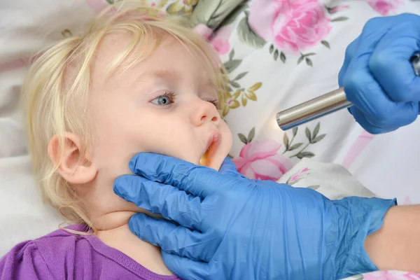 Lekarz Niebieskich Rękawiczkach Bada Chore Dziecko Latarką — Zdjęcie stockowe