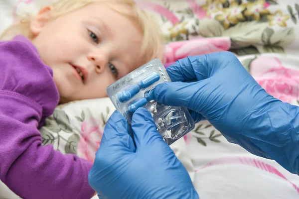 一个戴蓝色手套的医生给生病的儿童吃药 药物治疗 — 图库照片