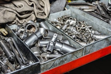 Kirli ve çalışan çilingir anahtarları bir araba atölyesindeki tamir kutusunda..