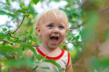 Kirli yüzlü küçük bir kız ağaca tırmandı ve gülümsedi.