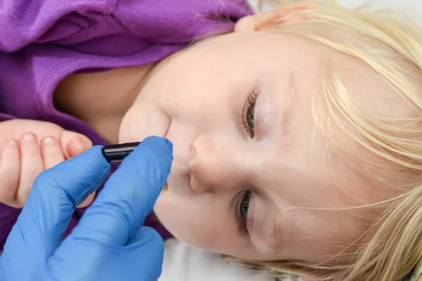 一个戴蓝色手套的医生给生病的孩子开了一个黑色的药囊 — 图库照片