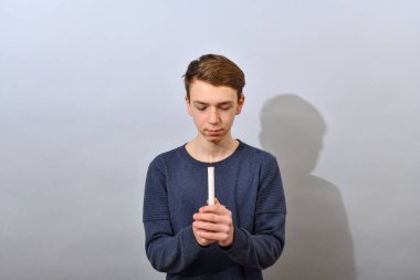 Çocuk önünde yanan bir mum tutuyor ve ona bakıyor. Putperestliğin Paskalya servisi.