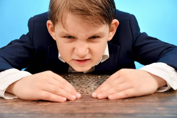 An angry and greedy child hides money so that no one can take it.