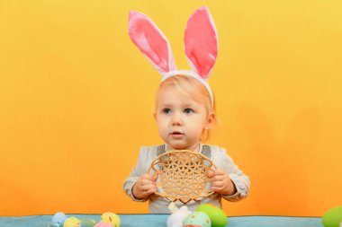 Küçük kız Paskalya tatili için boyanmış Paskalya yumurtaları için boş bir sepet gösteriyor..