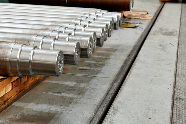Rolling shafts on racks in a warehouse.