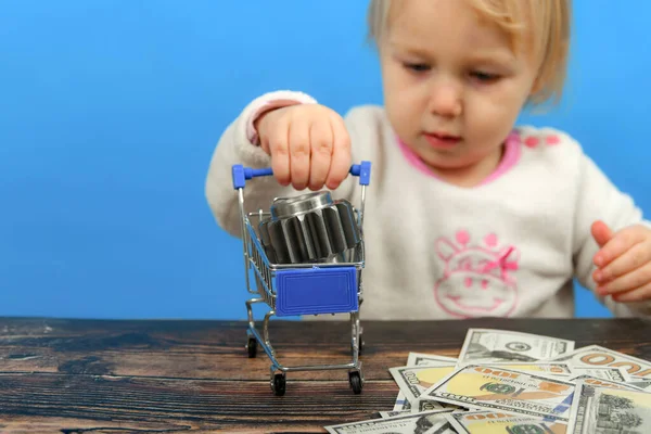 A cogwheel lies in a shopping cart and a child carries it on dollar bills. The concept of advertising cleanliness and decency in the manufacture of products.