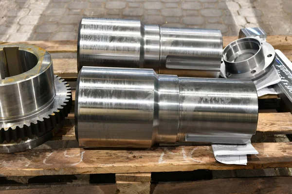 Shaft and gear on a rack after turning, milling and gear cutting on a machine.