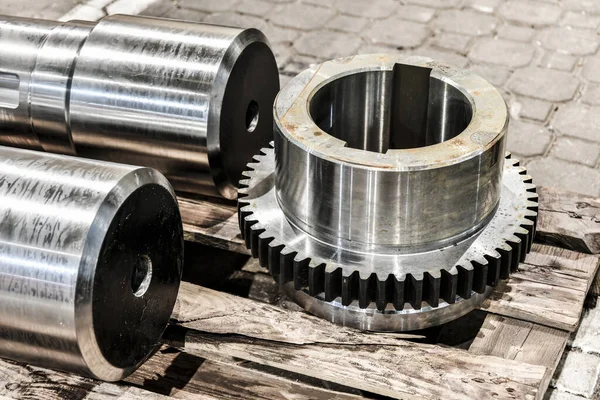 Shaft and gear on a rack after turning, milling and gear cutting on a machine.