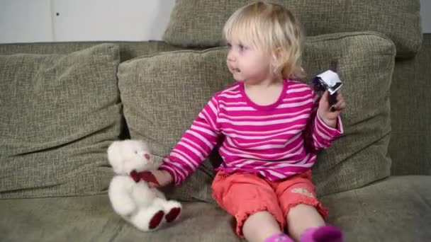 Niña Comiendo Caramelos Chocolate Mientras Está Sentada Sofá Cara Del — Vídeo de stock