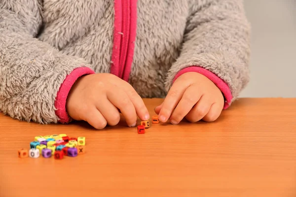 Uma Criança Pequena Brinca Com Letras Coloridas Tenta Colocá Las — Fotografia de Stock