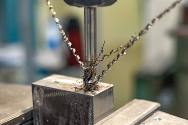 Bir parçada delik açmak için bir makineye tıklama.