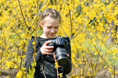 Genç bir kız parkta SLR kamerasıyla doğayı fotoğraflıyor..