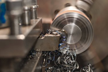 Torna tezgahında kesiciyle budamayı bitir. Makinede metal kırıntıları var..