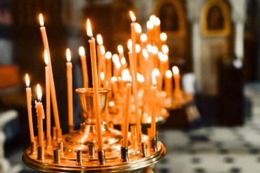 Tapınakta Tanrı 'ya ibadet etmek için kilise mumlarını yakmak..