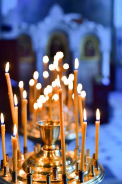 Tapınakta Tanrı 'ya ibadet etmek için kilise mumlarını yakmak..