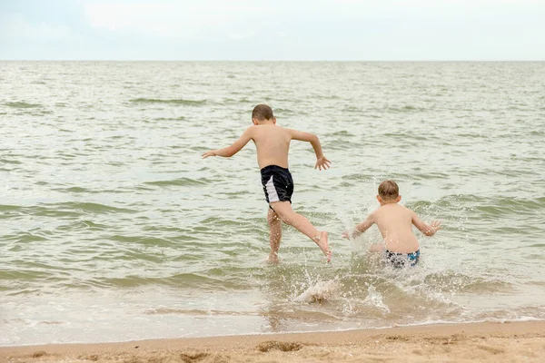 Dwóch Chłopców Skacze Nurkuje Wodzie Morskiej — Zdjęcie stockowe