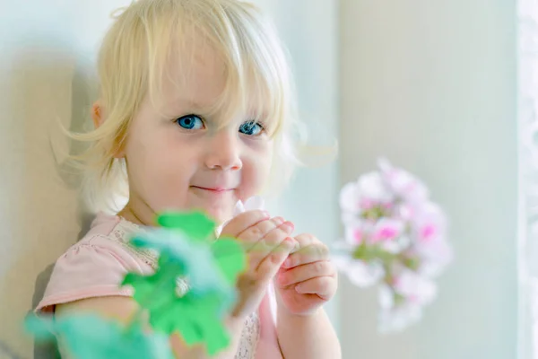Une Petite Fille Tient Des Fleurs Dans Ses Mains Regarde — Photo