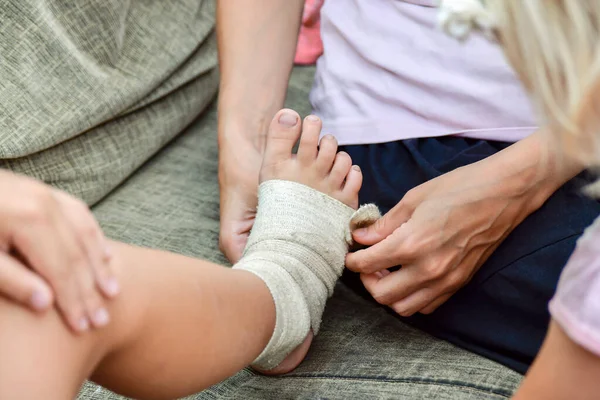 Anya Bekötözi Sebet Kislánya Lábán — Stock Fotó