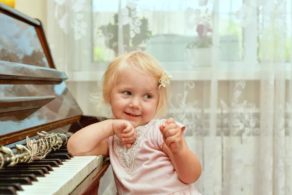 Uma Menina Alegre Está Apoiando Nas Teclas Piano Acenando Com — Fotografia de Stock