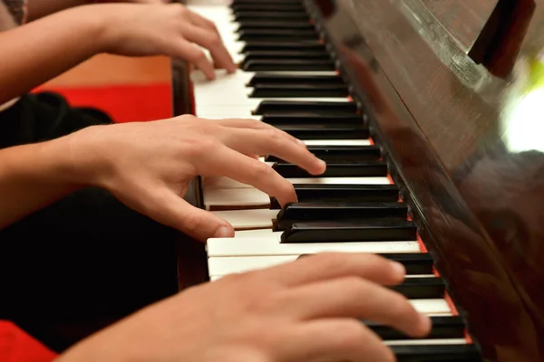 소녀와 남자가 손으로 피아노를 합니다 학교에서의 — 스톡 사진