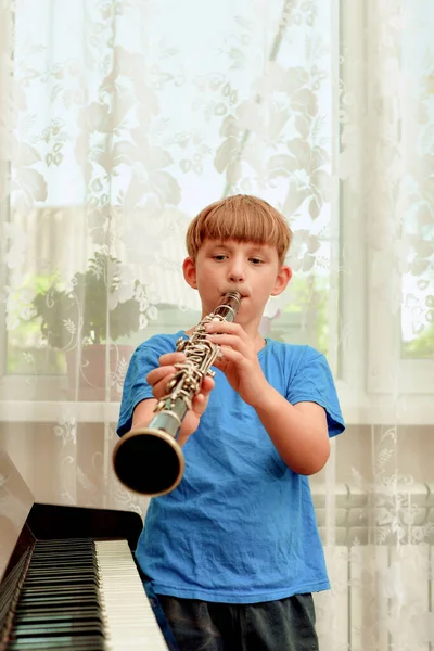 Boy Stands Next Piano Plays Clarinet Music School — Stock Fotó
