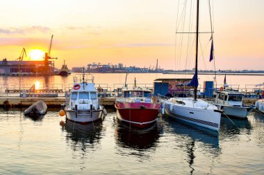 Yat kulübünde yelkenli teknelerle anakara akşam gökyüzü ve güneşli günbatımına karşı..