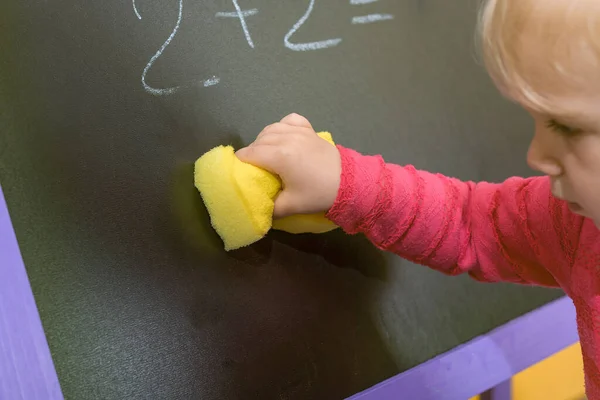 Dziecko Wyciera Tablicę Wilgotną Gąbką Napisów Rysunków Koncepcja Edukacji Przedszkolnej — Zdjęcie stockowe