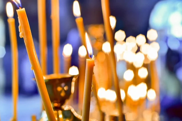 Candlesticks for church candles in the temple with burning candles during Christian worship.