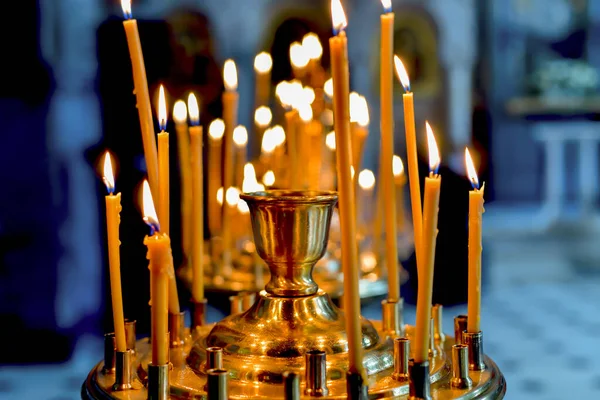 Candlesticks for church candles in the temple with burning candles during Christian worship.