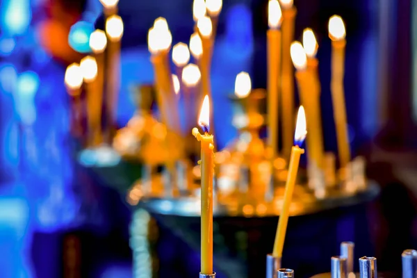青の背景に正教会の神聖なサービス上の黄色のワックス燃焼キャンドル — ストック写真