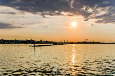 Denizde gün batımı, kargo limanı. Deniz manzarası.