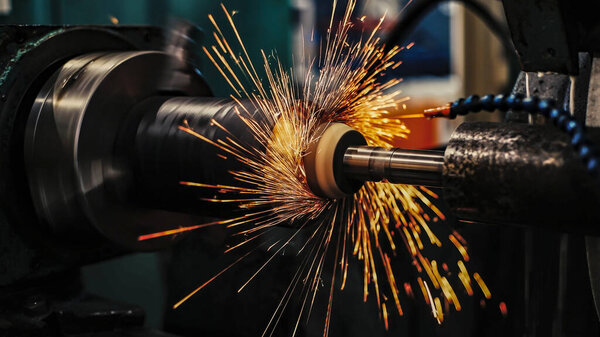 Внутреннее шлифование металла с искрами с абразивным камнем на круглошлифовальном станке.