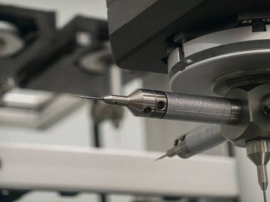 Close-up of precision tools in a manufacturing facility, showcasing a detailed view of a rotary tool in action. The setup highlights engineering and technology at work.